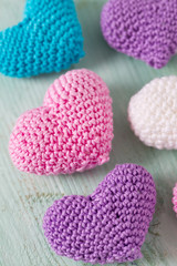 knitted hearts on turuoise wooden surface