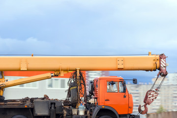 Truck crane drive on the road against the background of the city