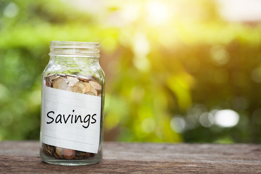 Savings word with coin in glass jar,  Business Concept.
