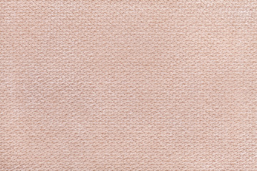 Beige fluffy background of soft, fleecy cloth. Texture of textile closeup