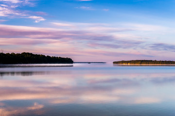 Fototapeta na wymiar Lake at sunrise with vivid colors reflected in water of Lake Manitoulin