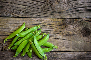 fresh green peas over a natural wood table, placed in  nice way