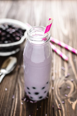 Homemade milkshake with berries on wooden background