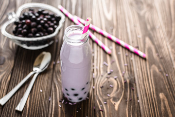 Homemade milkshake with berries on wooden background
