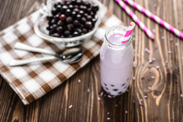 Homemade milkshake with berries on wooden background