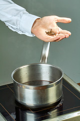 The cook sips the ingredients in a pan for cooking mulled wine full of culinary recipes