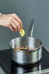 The cook sips the ingredients in a pan for cooking mulled wine full of culinary recipes