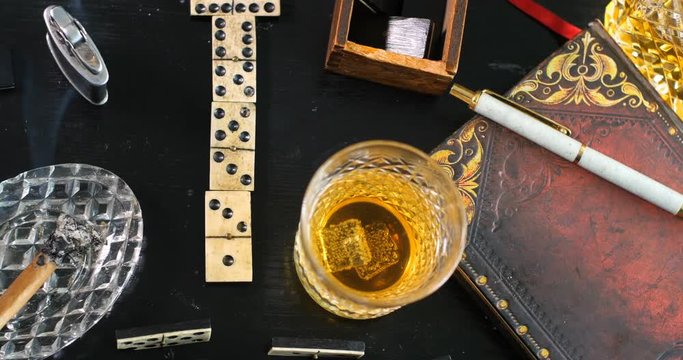 Dolly top down view: Playing a game of domino with a glass of whiskey and a cigar
