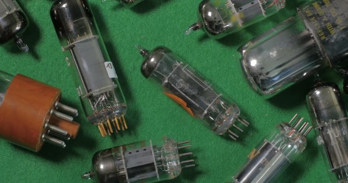 Dolly top down view of a collection of vintage vacuum tubes (valves) tor music amplifiers manufactured in the forties