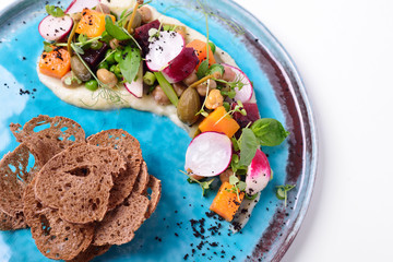 Modern venegret with capers, bread crisps, pumpkin and pear. The work of the chef on the road plate