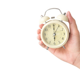 Hand holding retro alarm clock with white background