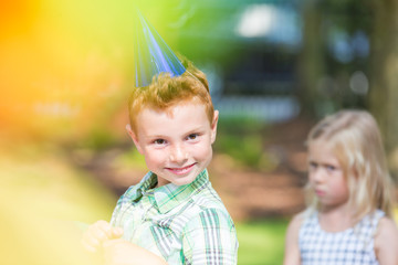 Small boy wearing birthday cap