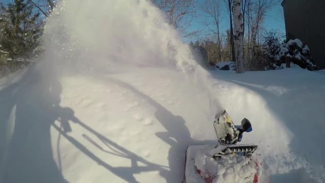Time lapse of an electric snow blower in action clearing snow from a driveway after a snow storm.