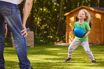 Boy playing ball with father