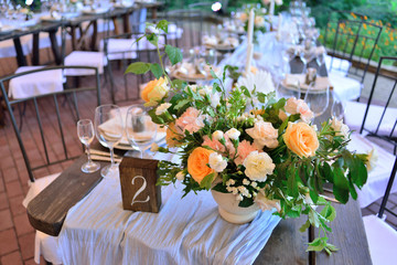 Wedding. Banquet. The chairs and table for guests, decorated with candles, served with cutlery and crockery and covered with a tablecloth.
