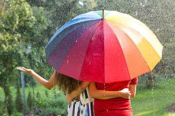 Couple under rainbow umbrella