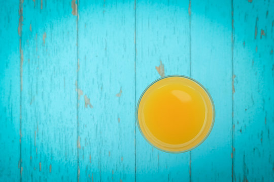 Glass of orange juice on blue wooden table. Blue wooden food background. Flat lay. Shallow DOF