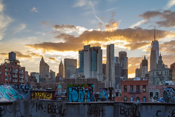Naklejka premium New York City Skyline o zachodzie słońca z Graffiti Covered Rooftops of Manhattan