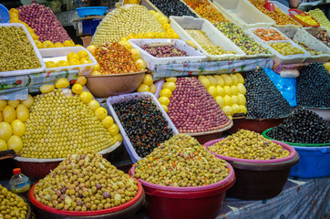Large amounts of pyramidically stacked olives for sale on market or soukh of Marrakesh, Morocco