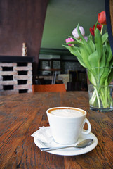 cup of cappuccino with spoon on the wooden table background