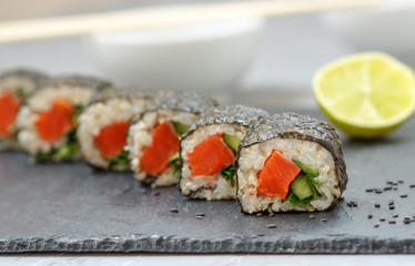 Healthy homemade sushi rolls with brown rice, fish and green vegetable rolls.