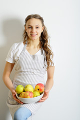 Fresh apples in the hands of a young girl in an apron, chef, healthy lifestyle