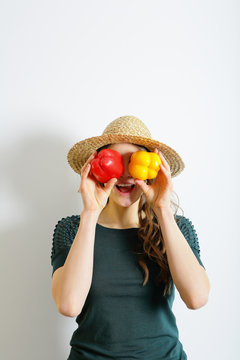 Smiling woman holding pepper in her hands, fun, playing with vegetables