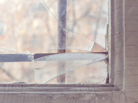 Broken glass on an old window with bars
