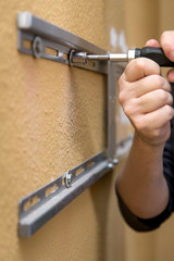 Nahaufnahme, Befestigung einer TV-Wandhalterung an der Wand