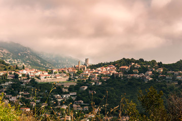 French village on top of mountain with pink sky