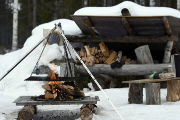 Hiking shelter in winter with a burning fire