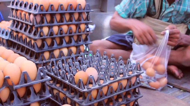 merchant pick egg into plastic bag for sell