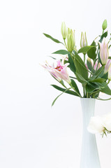 Fototapeta na wymiar Bouquet of white lilies in a white vase on white background,for background
