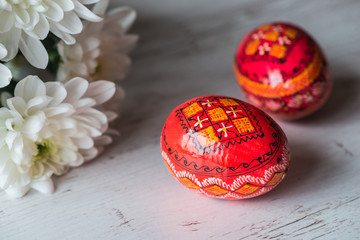 Easter Background with easter eggs and spring flowers on light wooden background