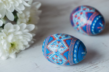 Easter Background with easter eggs and spring flowers on light wooden background