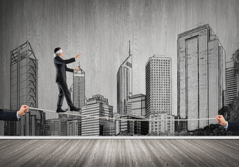 Business concept of risk support and assistance with man balancing on rope