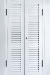 Closed window with white wooden exterior shutters