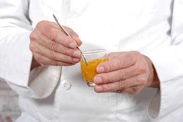 man hands holding pot of orange jam