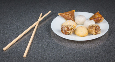 Delicious assortment of homemade Asian pastries. Samosas with a rose flower and banana balls