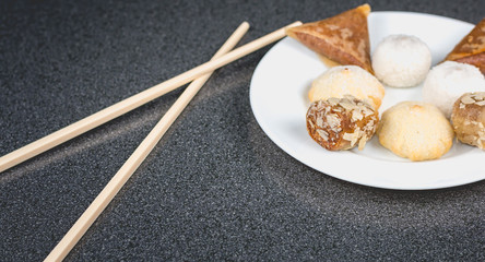 Delicious assortment of homemade Asian pastries. Samosas with a rose flower and banana balls