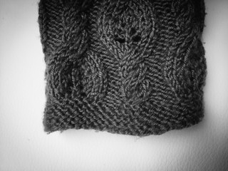 Close-up photo of black grey knitted crumpled textured surface background