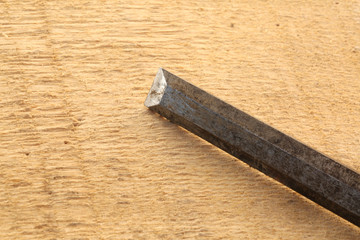 sharp chisel on rough wooden background