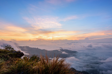 Naklejka na ściany i meble Beautiful landscape nature, sunrise on peak mountain with sun cloud fog and bright colors of sky in winter at Phu Chi Fa Forest Park is a famous tourist attraction of Chiang Rai Province, Thailand
