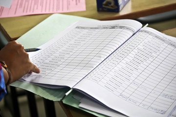 Close-up of hand holding pen with paper