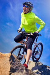 Fototapeta premium A cyclist who travels in the mountains in summer on a sunny day