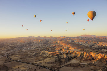 Balloons fly over the valley at dawn.
