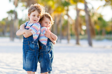 Two little kids boys having fun on tropical beach