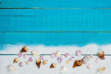 Teal blue beach sign with seashell and sand border