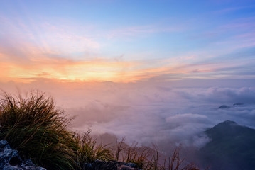 Beautiful landscape nature, sunrise on peak mountain with sun cloud fog and bright colors of sky in winter at Phu Chi Fa Forest Park is a famous tourist attraction of Chiang Rai Province, Thailand