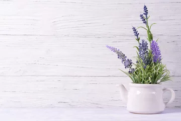 Raamstickers Lavendel bloemen in gieter, houten achtergrond, kopieer ruimte © pavkis